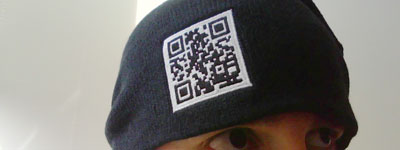 Black knit cap with embroidered black and white QR code.