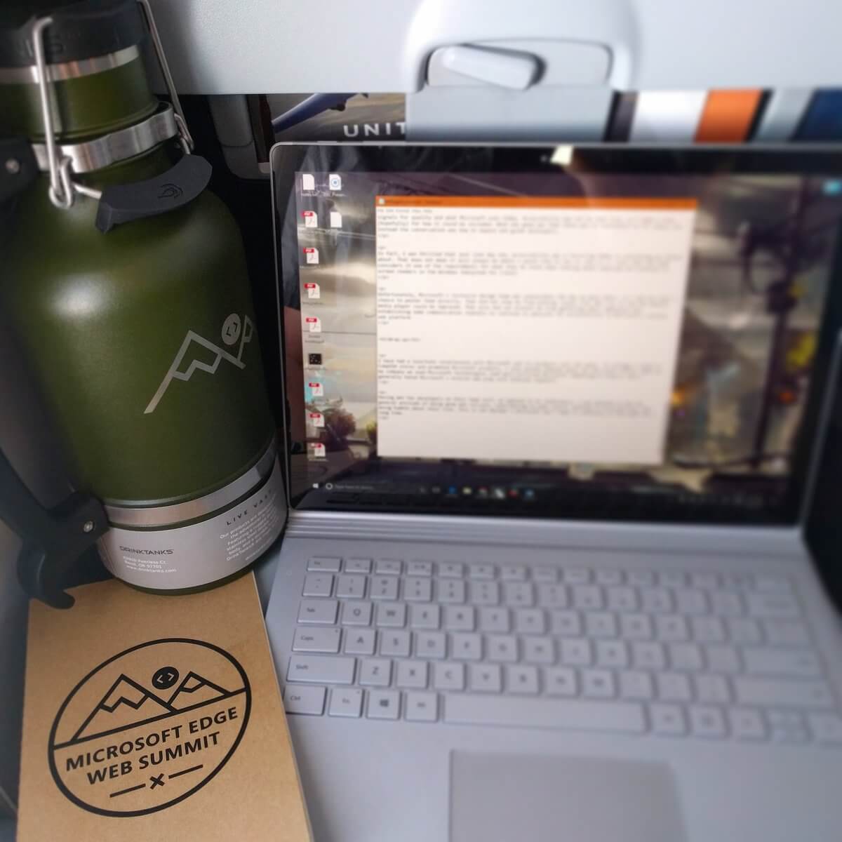 My laptop on the airplane tray table along with the free ‘Microsoft Edge Web Summit’ branded Moleskine. Crowding them both off the tray a bit and jammed up against the bulkhead is the giant insulated 64oz drink container, also emblazoned with ‘Microsoft Edge Web Summit’.